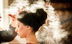 Hairstylist working in the bride's updo. Hairstylist working in the bride's updo.