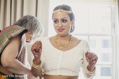 Lady helping indian bride to get ready for wedding ceremony Lady helping indian bride to get ready for wedding ceremony