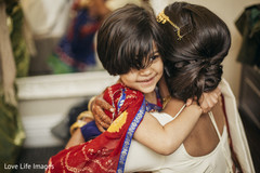 Indian bride hugging a kid before wedding ceremony Indian bride hugging a kid before wedding ceremony