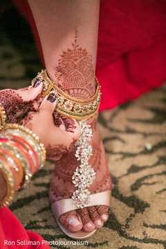 Bride getting some help to wear her anklets. Bride getting some help to wear her anklets.