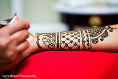Mehndi artist working on bride's arm. Mehndi artist working on bride's arm.