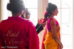 Hairstylist giving the final touch ups to the bride's updo. Hairstylist giving the final touch ups to the bride's updo.