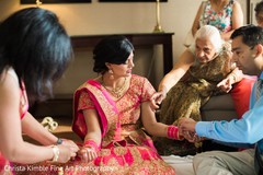 Indian bride getting help preparing her look. indian bride,indian bridal hair and makeup,indian bridal fashions,indian bride getting ready