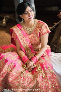Gorgeous bride wearing a golden and pink lengha. indian bride,indian wedding jewelry,indian bridal fashions,indian bride getting ready