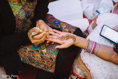 Mehndi artist working on the bride's hand. Mehndi artist working on the bride's hand.