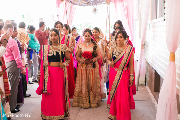 Indian bride escorted by her bridesmaids.