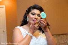 Bride takes a final look to her makeup. Bride takes a final look to her makeup.
