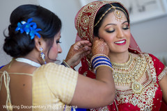 Indian bride trying her earrings before wedding ceremony Indian bride trying her earrings before wedding ceremony