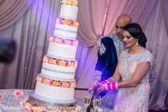 Indian couple cutting the cake at wedding reception indian wedding design,bride bangles,indian bride hair and makeup