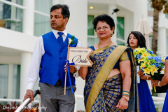 Indian bride parents holding a wedding sign Indian bride parents holding a wedding sign