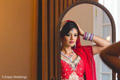 Bride taking a look to her bridal attire. indian bride,indian bride getting ready,indian bridal hair and makeup