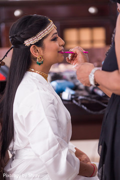 Indian bride getting some lip color. indian bride getting ready,indian bridal hair and makeup,indian bridal jewelry
