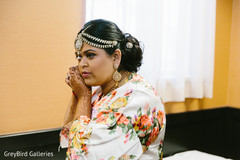 Indian bride trying her earrings before wedding ceremony Indian bride trying her earrings before wedding ceremony