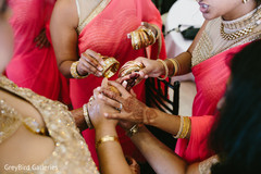 Indian bridesmaids helping the bride to get ready for wedding ceremony Indian bridesmaids helping the bride to get ready for wedding ceremony
