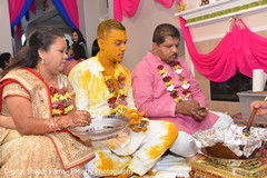 Groom and parents during Haldi ritual Groom and parents during Haldi ritual