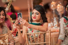 Indian lady taking a picture at wedding reception Indian lady taking a picture at wedding reception