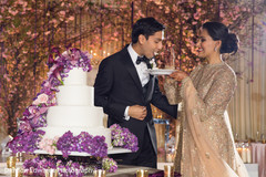 Indian couple eating cake at wedding reception indian wedding cake design,indian wedding reception floral and decor,indian wedding gallery