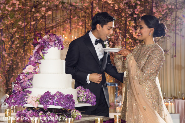 Indian couple eating cake at wedding reception