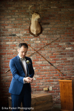 Indian groom wearing a blue wedding suit with white boutonniere Indian groom wearing a blue wedding suit with white boutonniere