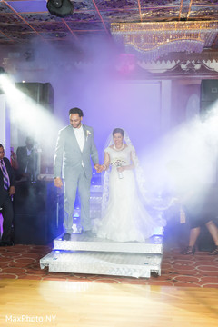 Indian bride and groom making their entrance at wedding reception indian bride reception fashion,indian groom suit,indian bride and groom