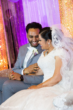 Indian bride and groom having a good time at wedding reception indian groom suit,boutonniere,indian bride reception fashion,indian wedding reception