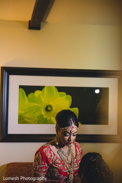 Beautiful indian bride being dolled up for her ceremony indian bride hair and makeup,indian bride getting ready,bridal jewelry,bridal tikka