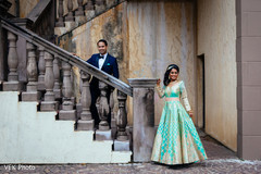 Indian bride and groom posing on stairs indian groom suit,indian bride fashion,outdoor photography
