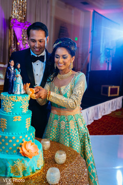 Indian bride and groom cutting the wedding cake indian wedding cake,indian wedding reception,indian bride fashion,indian groom suit