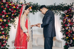 Indian groom putting wedding ring on bride Indian groom putting wedding ring on bride