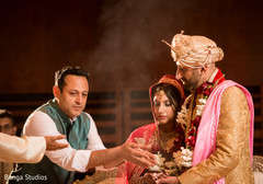 Indian priest pouring rice on bride and groom's hands indian groom fashion,indian bride fashion,indian wedding ceremony