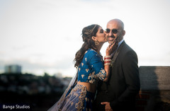 Indian bride kissing groom's cheek indian groom suit,indian bride lengha,bride bangles