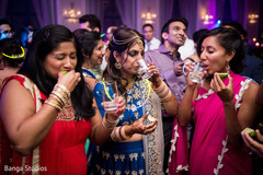 Indian bride having a drink with guests indian wedding reception,indian bride lengha,bridal jewelry