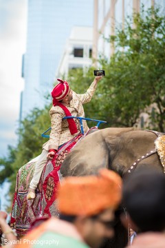 Indian groom taking a selfie while riding an elephant Indian groom taking a selfie while riding an elephant