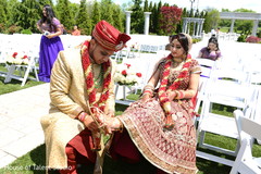 Indian bride putting on her shoes with groom's help indian wedding ceremony,indian bride lengha,indian groom sherwani