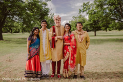 Indian bride and groom posing with family Indian bride and groom posing with family