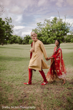 Indian bride and groom walking holding hands Indian bride and groom walking holding hands