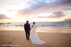 Indian bride and groom walking holding hands Indian bride and groom walking holding hands