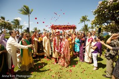 Indian couple leaving the mandap while being showered with rose petals Indian couple leaving the mandap while being showered with rose petals