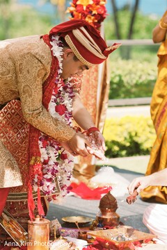 Indian bride and groom pouring rice to sacred fire Indian bride and groom pouring rice to sacred fire