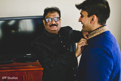Indian groom's father helping him to get ready Indian groom's father helping him to get ready
