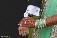 Lovely indian bride holding groom's hand bride bangles,wedding rings,indian bridal mehndi