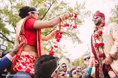 Indian bride putting a flower garland to groom milni ceremony,indian bride fashion,indian groom fashion