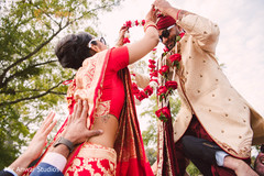 Beautiful indian bride putting a flower garland to groom indian groom fashion,indian bride fashion,milni ceremony