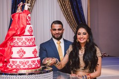 Indian bride and groom posing with the wedding cake indian bride and groom,indian wedding cake,indian wedding reception