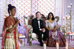 Indian newlyweds listening to a wedding speech sari,indian bride fashion,indian groom fashion