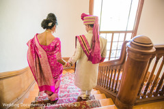 Indian bride and groom walking down the stairs Indian bride and groom walking down the stairs
