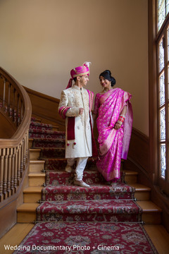 Enchanting indian bride and groom walking down the stairs holding hands Enchanting indian bride and groom walking down the stairs holding hands