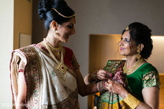 Indian bride getting some help with her accessories Indian bride getting some help with her accessories