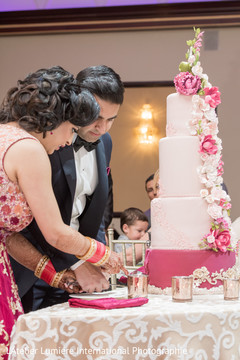Adorable indian couple cutting the cake indian bride and groom,indian wedding reception,indian wedding cake