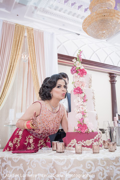 Beautiful indian bride posing with wedding cake indian wedding reception,indian bride and groom,indian wedding cake